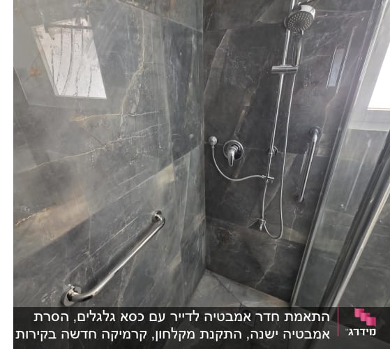 מקלחת משופצת עם אריחים כהים וברזים חדשים